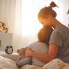 morning awakening. mother wakes her daughter in bed in morning