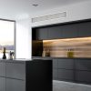 Side view of a panoramic black and wooden kitchen interior with black countertops and an island. 3d rendering mock up